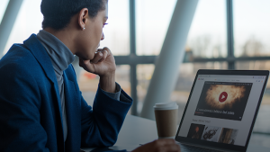 a woman using a website with a video in it. a woman using a website with a video in it.